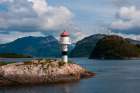 A small lighthouse perched on a rock promontory in Hollandsfjord-Svartisen-Norway Art Print